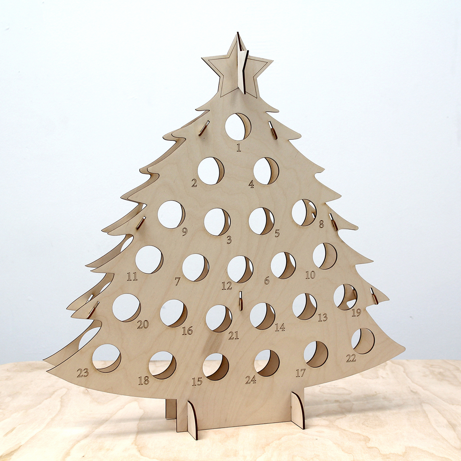 Empty plywood bottle tree advent calendar in front of white background