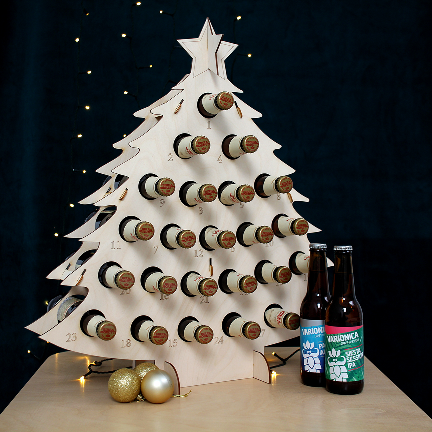 Filled bottle advent calendar in front of black background with fairy lights