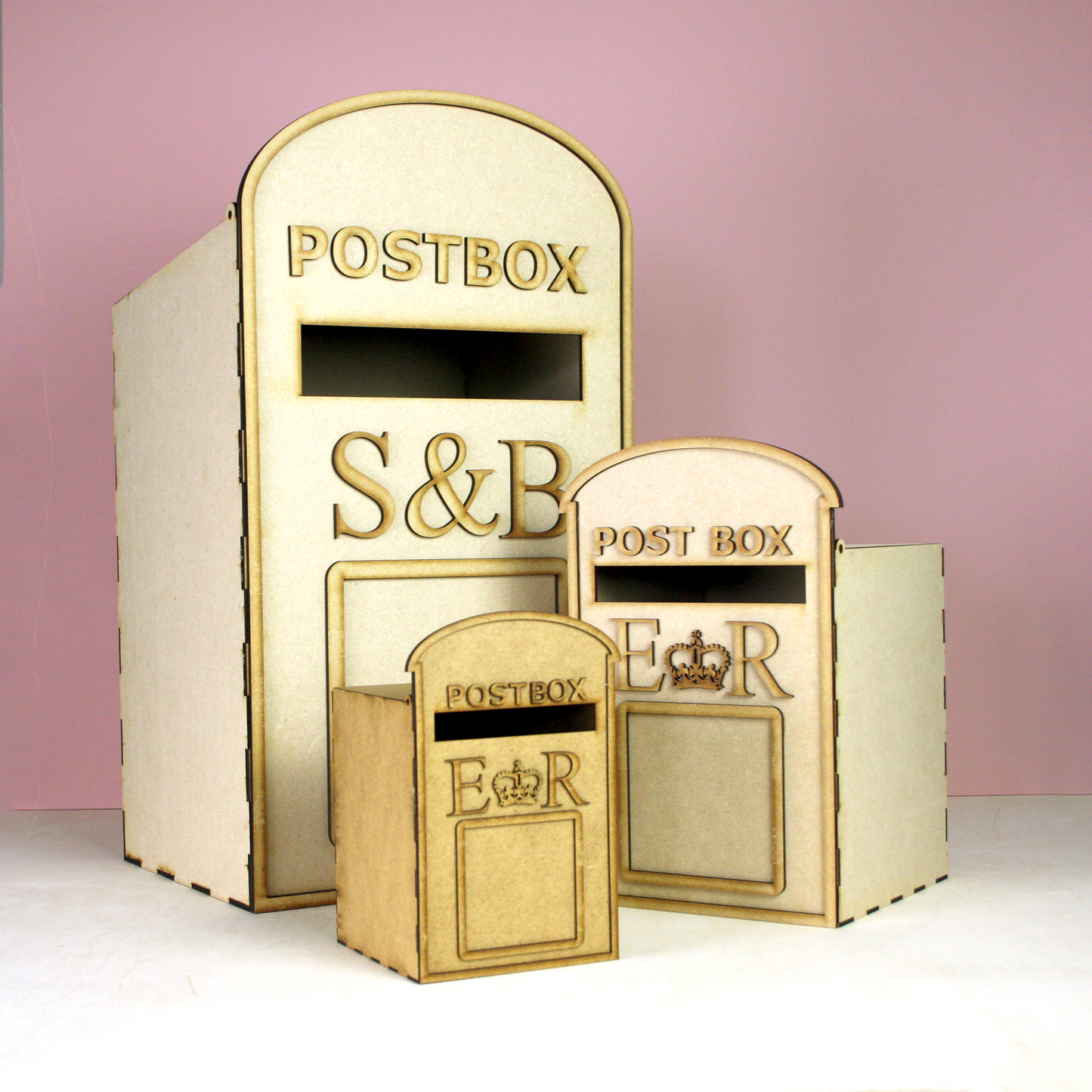 Set of three MDF postboxes on pink background