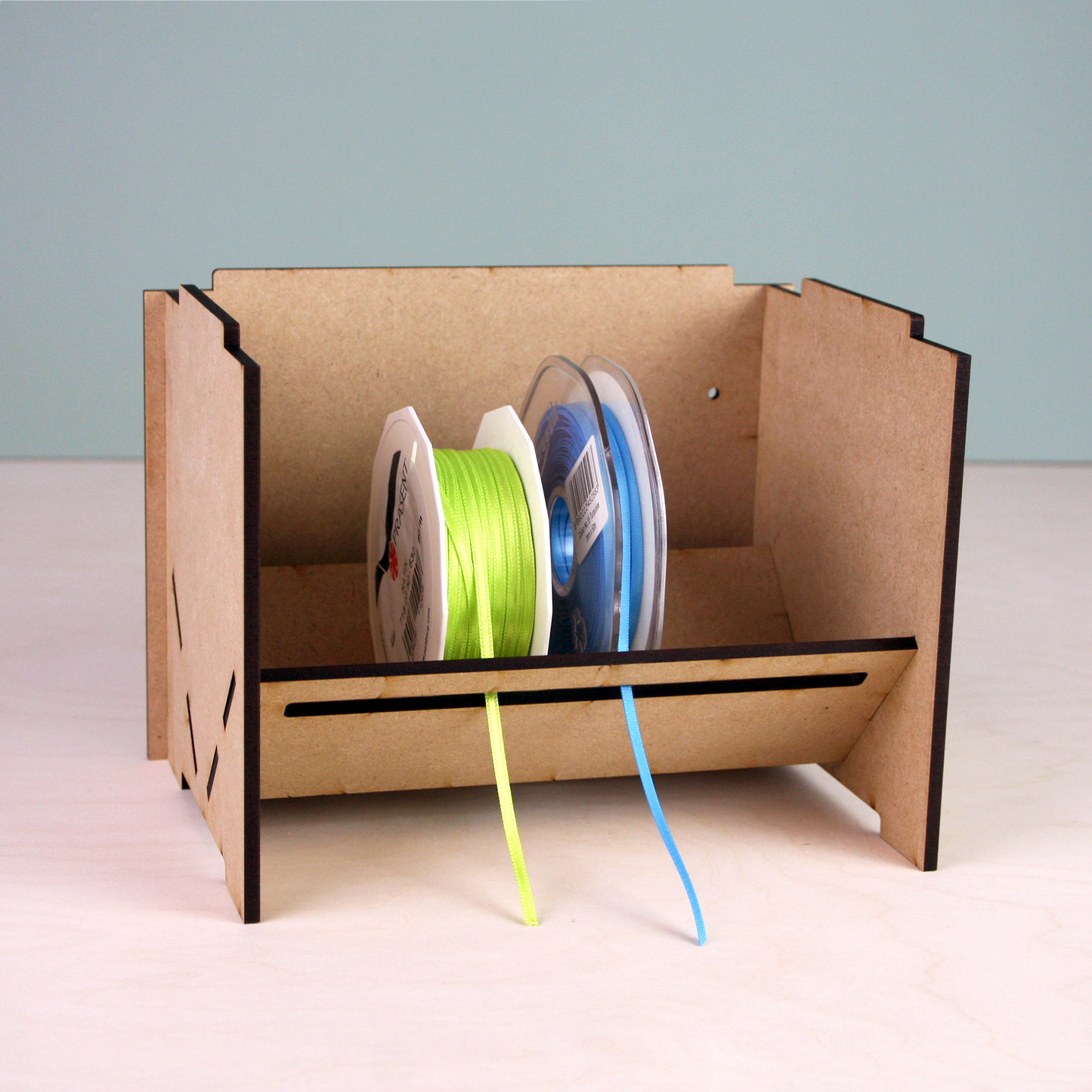 Laser cut MDF ribbon holder in front of green background