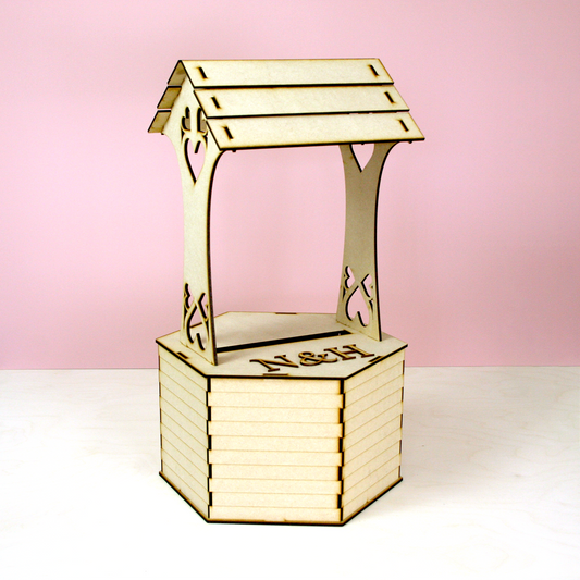 MDF wishing well shaped postbox for cards in front of pink background