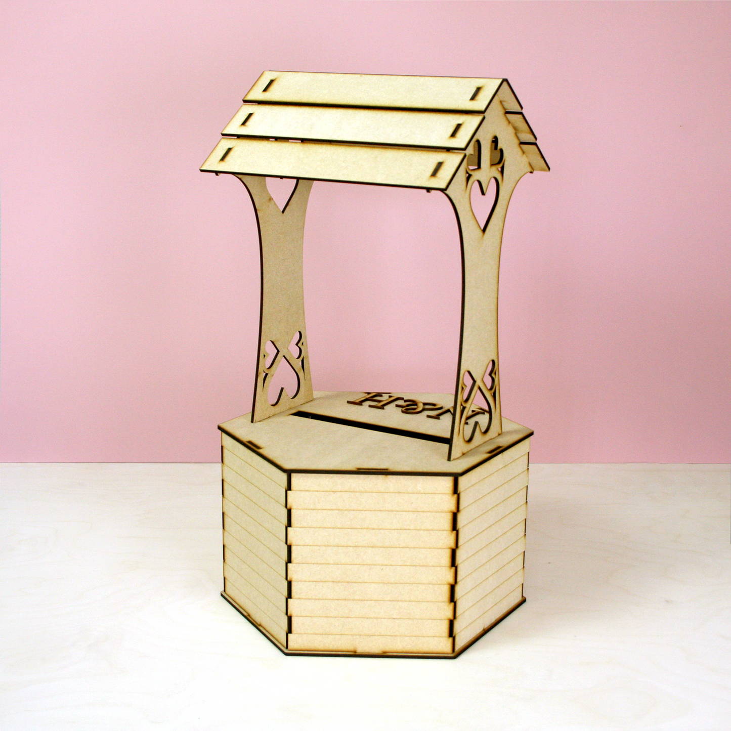 MDF wishing well shaped postbox for cards in front of pink background